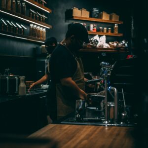 Barista đang chuẩn bị cà phê espresso bằng máy pha tại quầy