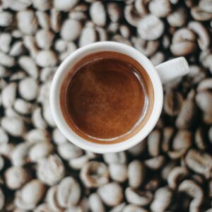 Tách espresso đặt trên nền hạt cà phê rang